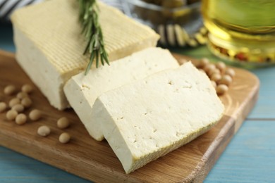 Cut tofu and soya beans on blue wooden table, closeup