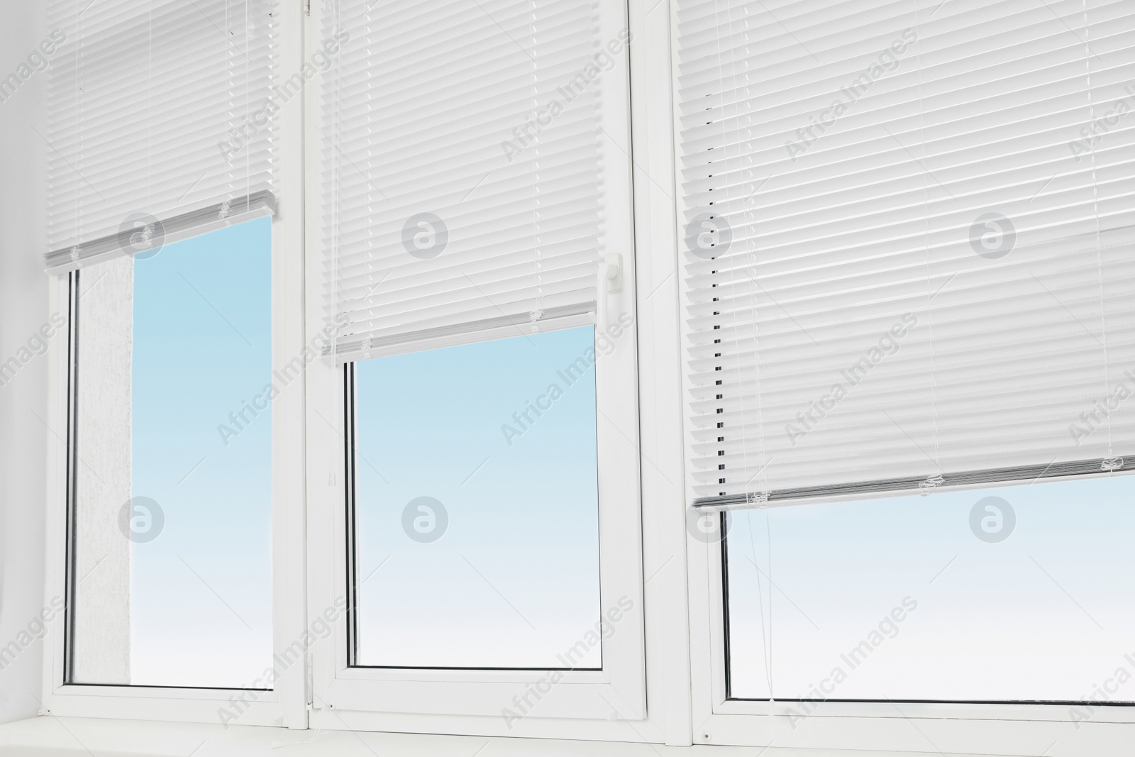 Photo of Stylish window with horizontal blinds in room