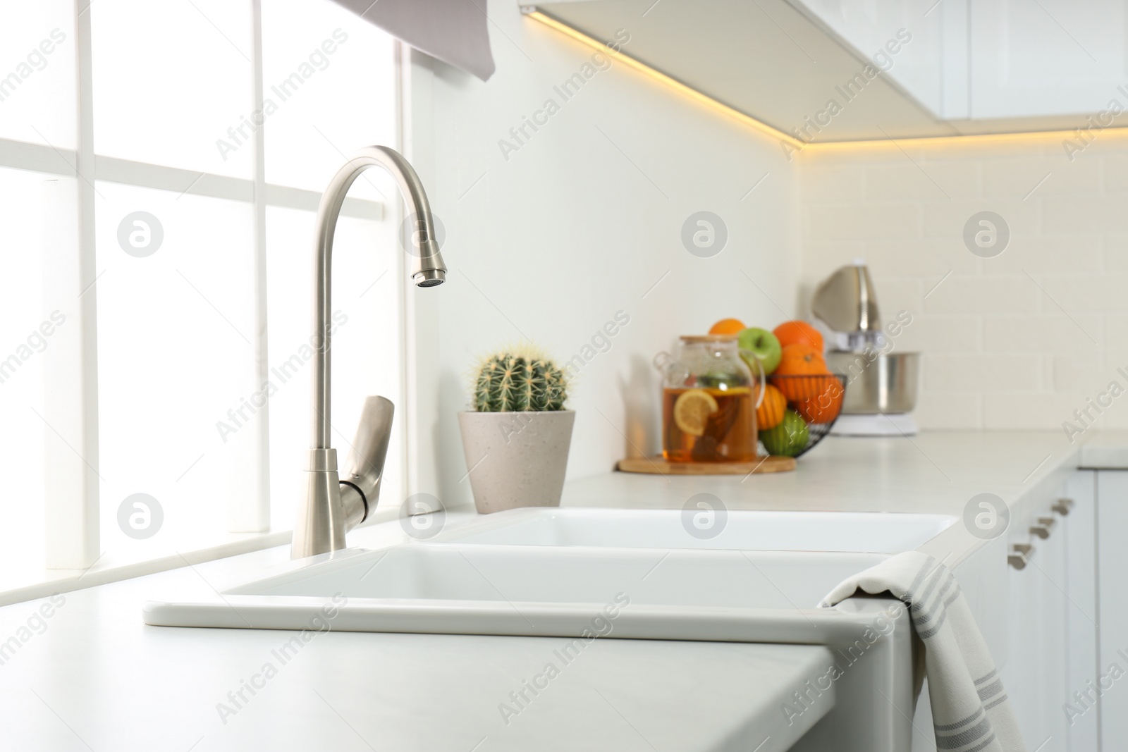 Photo of Ceramic sink and modern tap in stylish kitchen interior