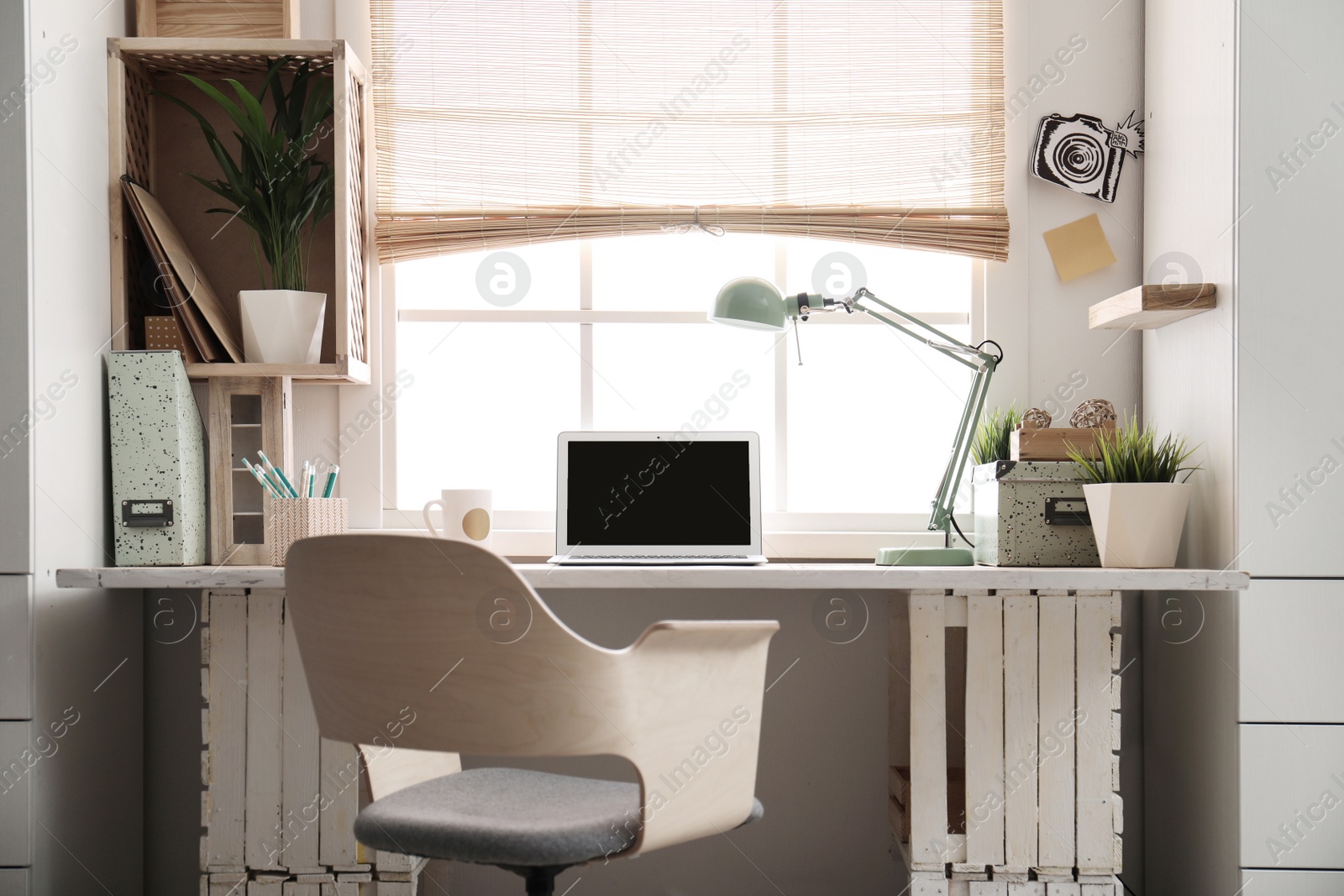 Photo of Modern home workplace with wooden crates. Eco style interior