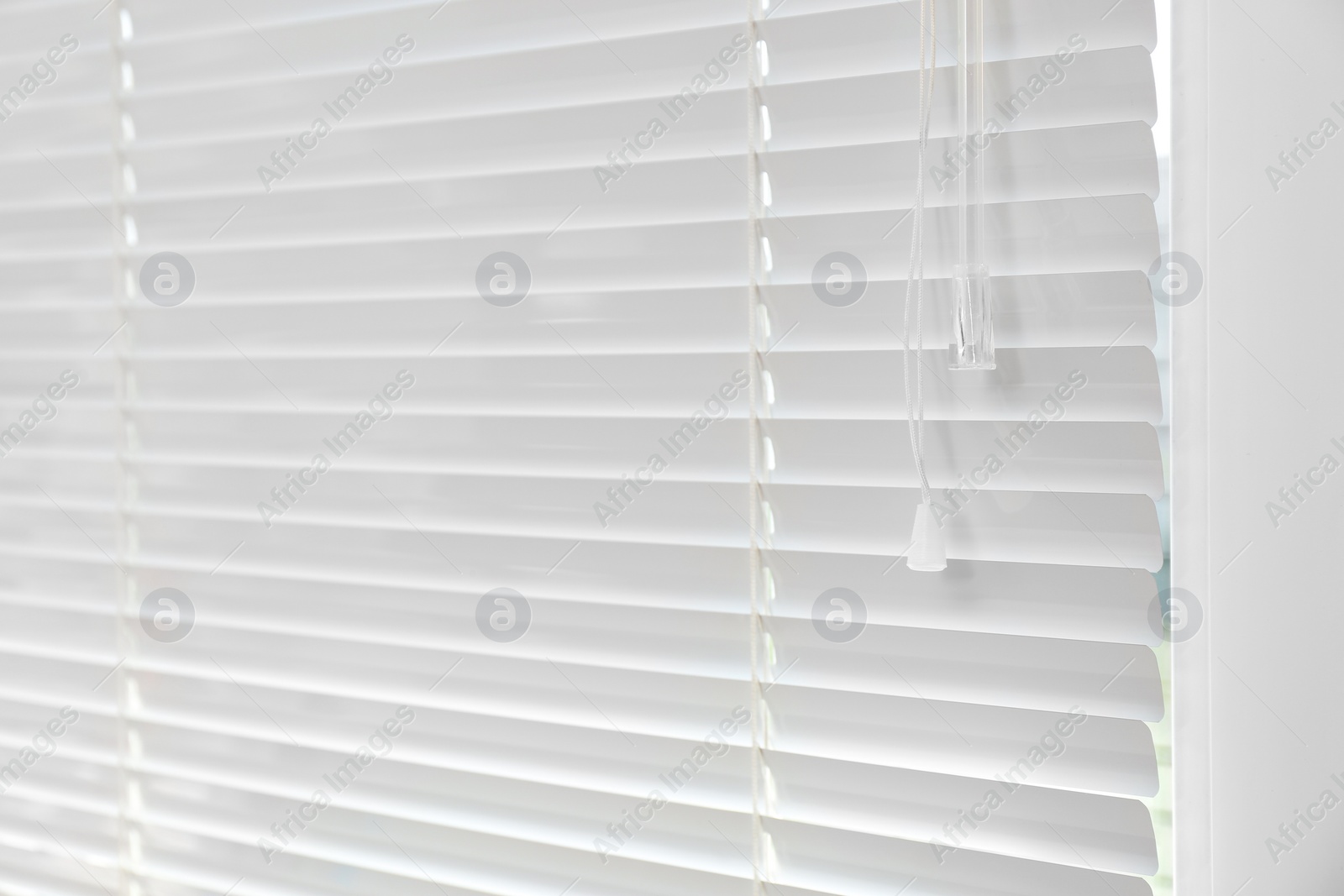 Photo of Window with closed modern horizontal blinds indoors. Space for text