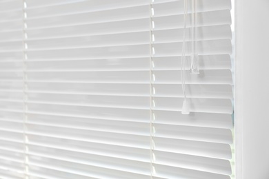 Photo of Window with closed modern horizontal blinds indoors. Space for text