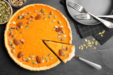 Photo of Delicious homemade pumpkin pie on black table, flat lay