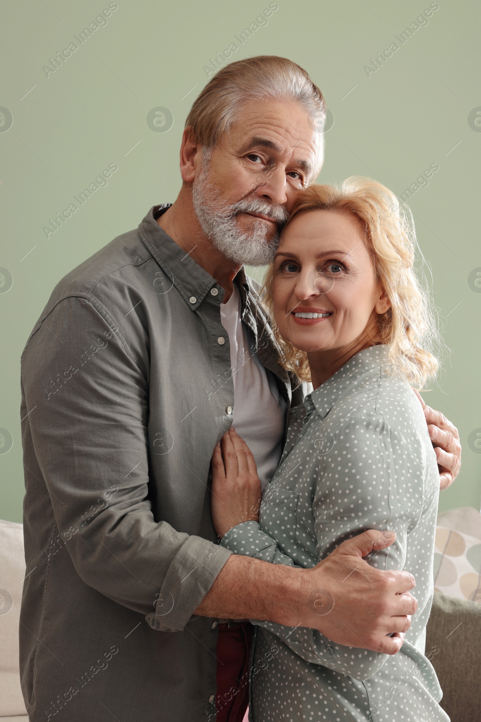 Photo of Happy mature couple hugging at home. Dating agency