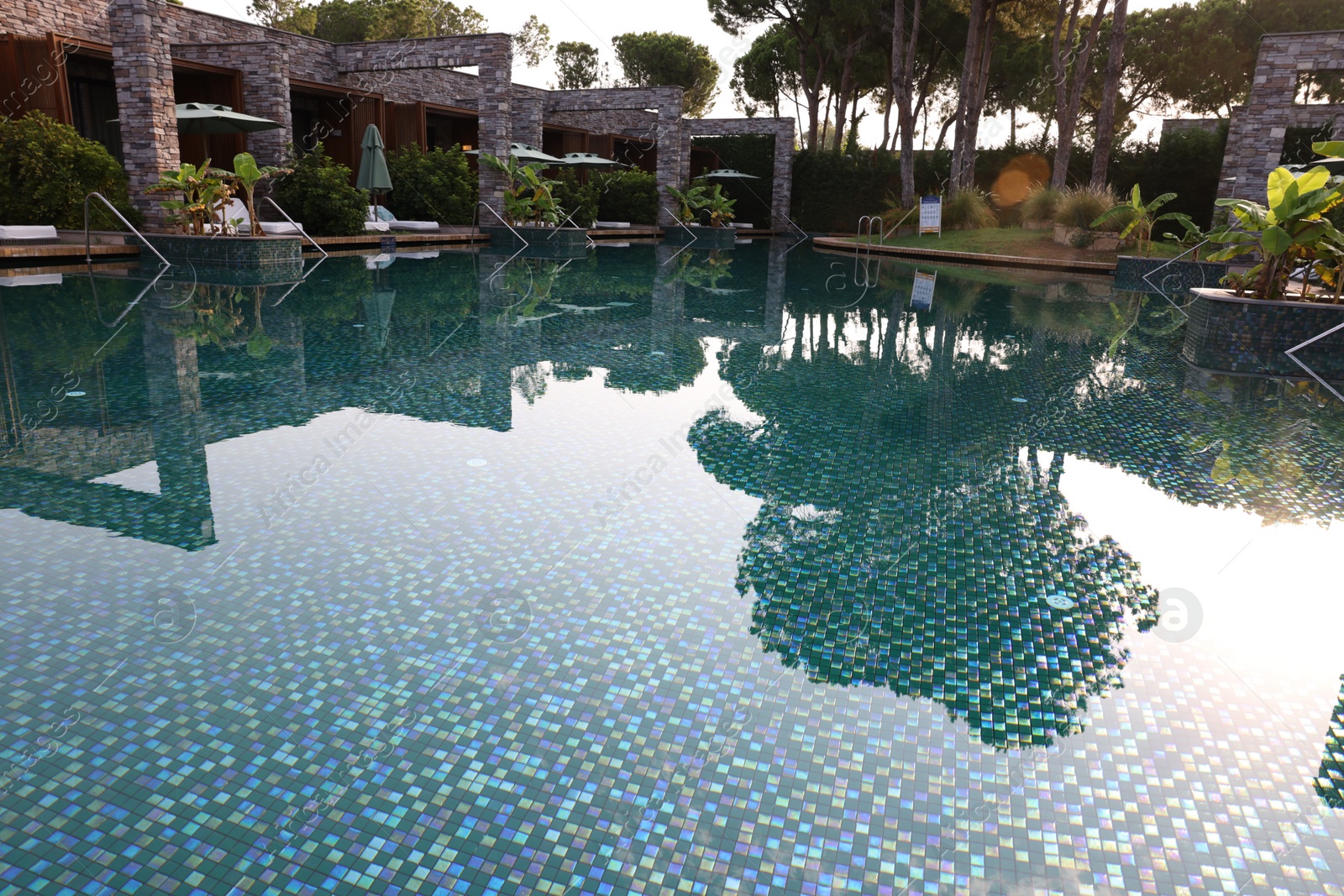 Photo of Outdoor swimming pool with umbrellas and sunbeds at resort