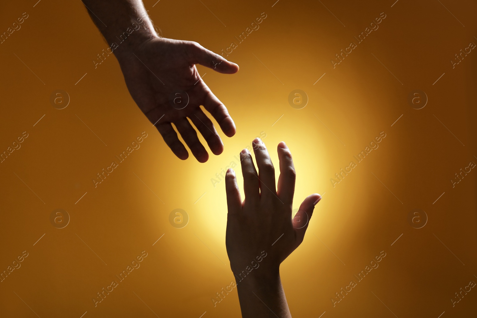 Photo of Man reaching for woman's hand on color background, closeup. Help and support concept