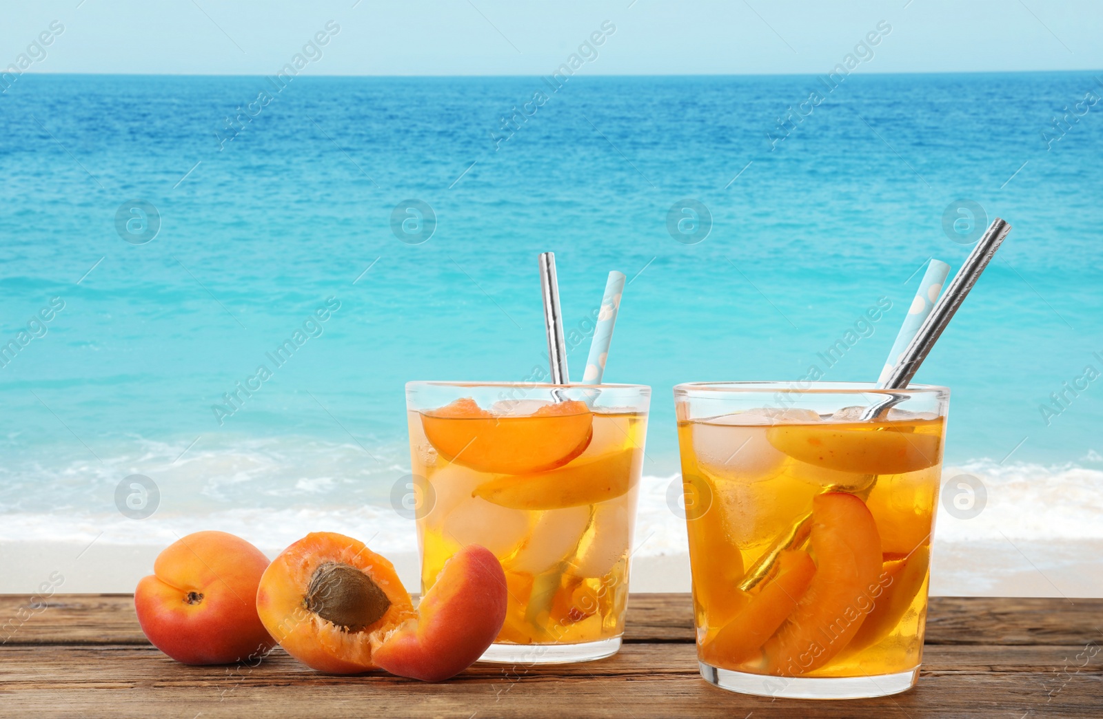 Image of Tasty refreshing drink on wooden table against sea