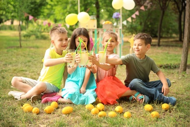 Photo of Little children with natural lemonade in park