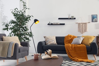 Photo of Stylish living room interior with comfortable sofa and wooden table