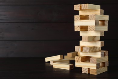 Photo of Jenga tower and wooden blocks on table, space for text