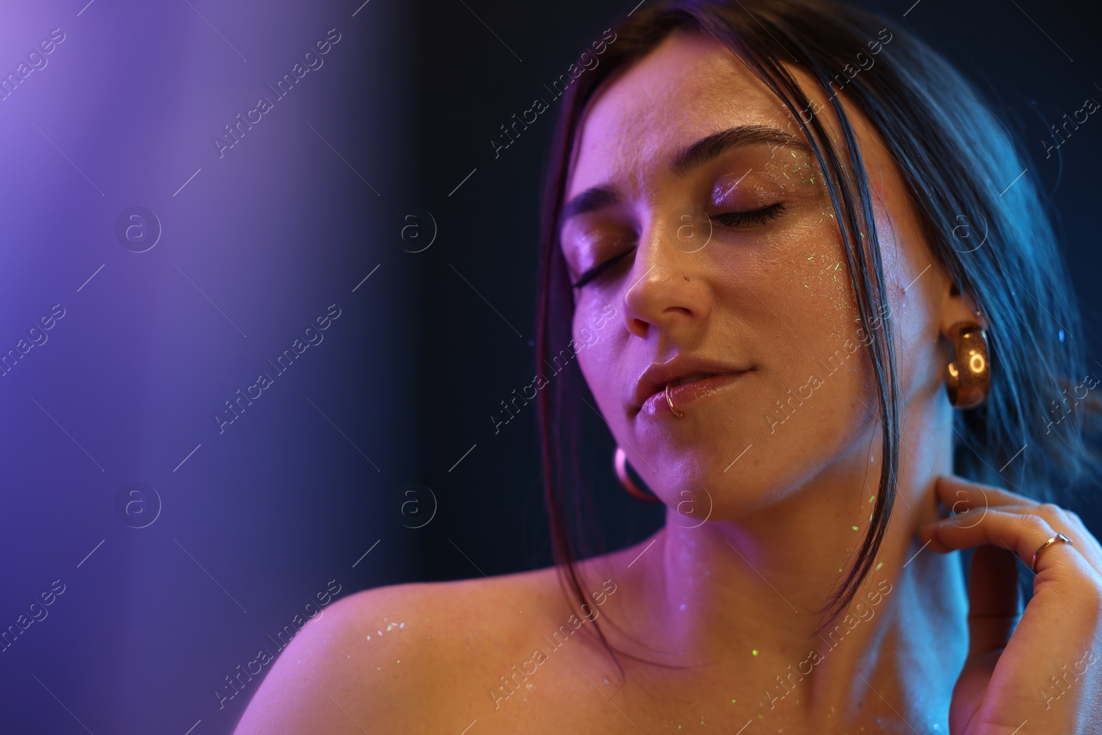 Photo of Portrait of beautiful woman on dark background in neon lights, space for text