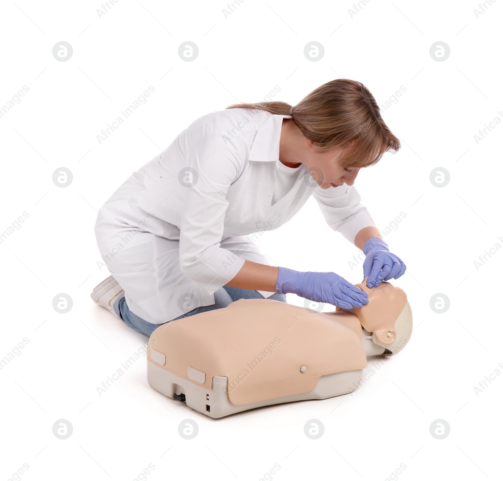 Photo of Doctor in uniform practicing first aid on mannequin against white background