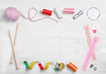 Photo of Flat lay composition with sewing threads and accessories on wooden background