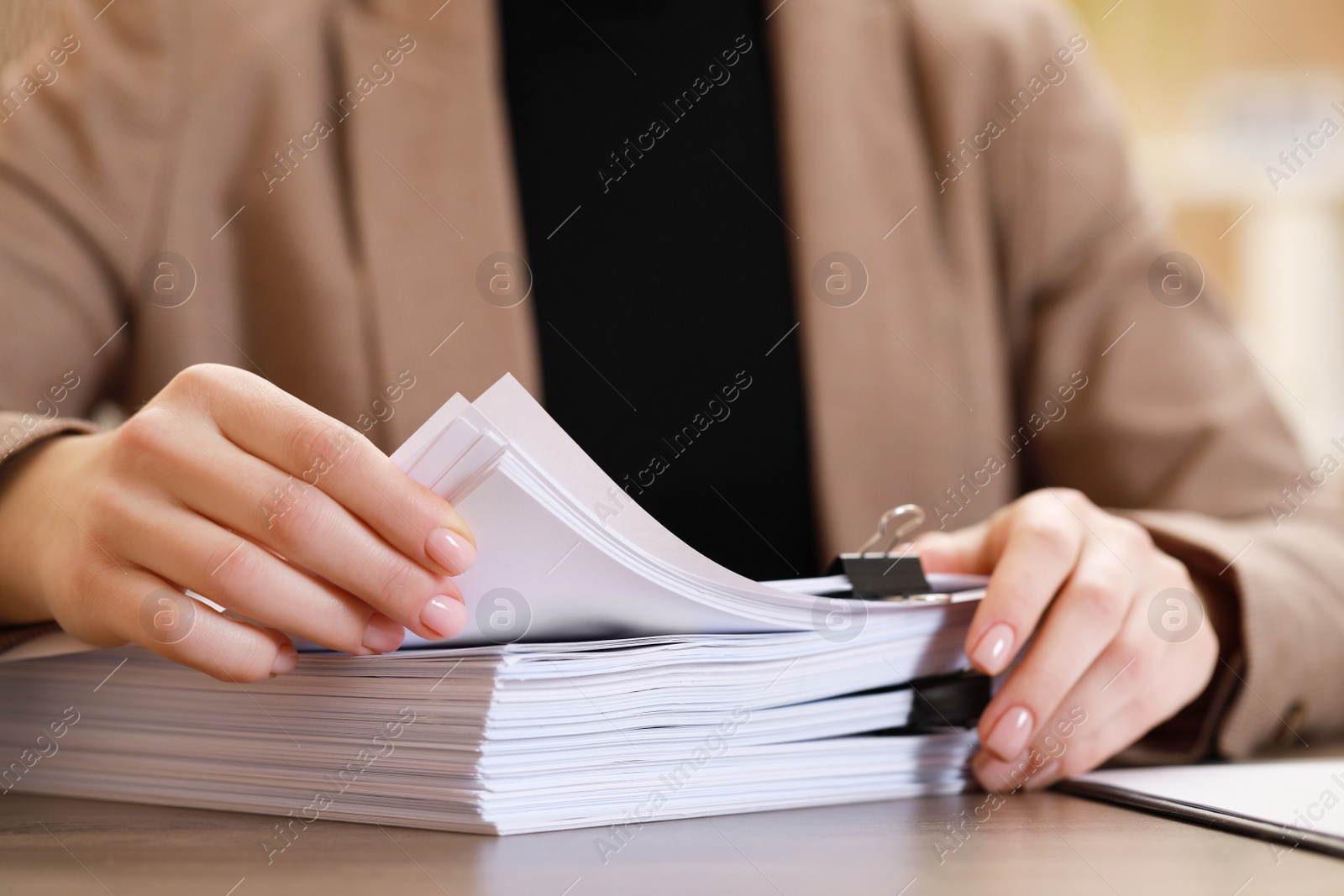 Photo of Woman working with documents at table in office, closeup