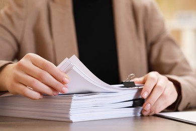 Woman working with documents at table in office, closeup