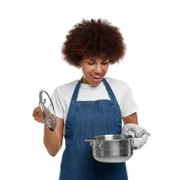 Happy young woman in apron holding cooking pot on white background