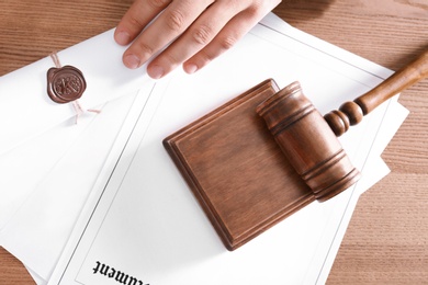 Photo of Male notary working at wooden table, top view