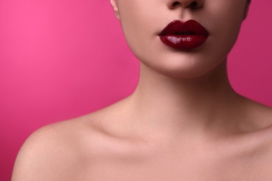 Photo of Closeup view of woman with beautiful full lips on pink background