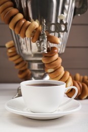 Cup of tea and delicious ring shaped Sushki (dry bagels) on white wooden table