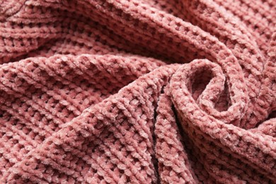 Beautiful pink knitted fabric as background, closeup