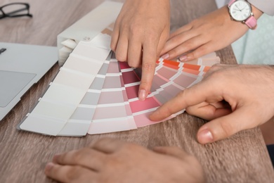 Photo of Team of designers working with color palette at office table, closeup