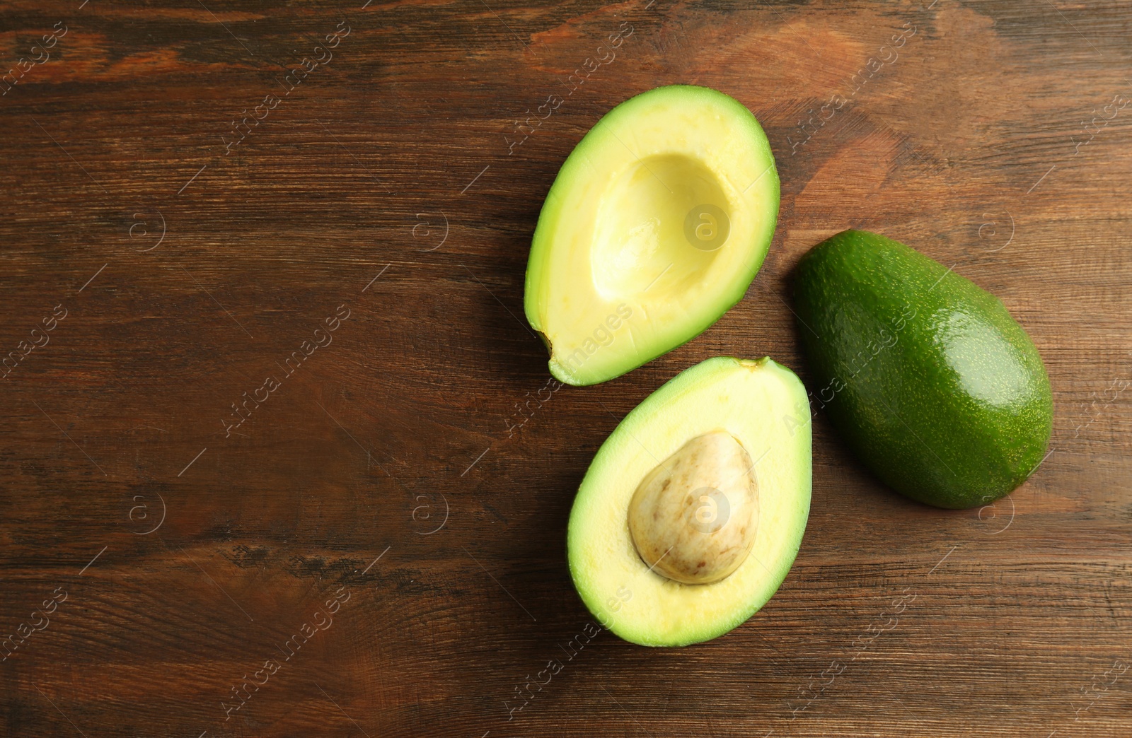 Photo of Tasty ripe green avocados on wooden background, top view