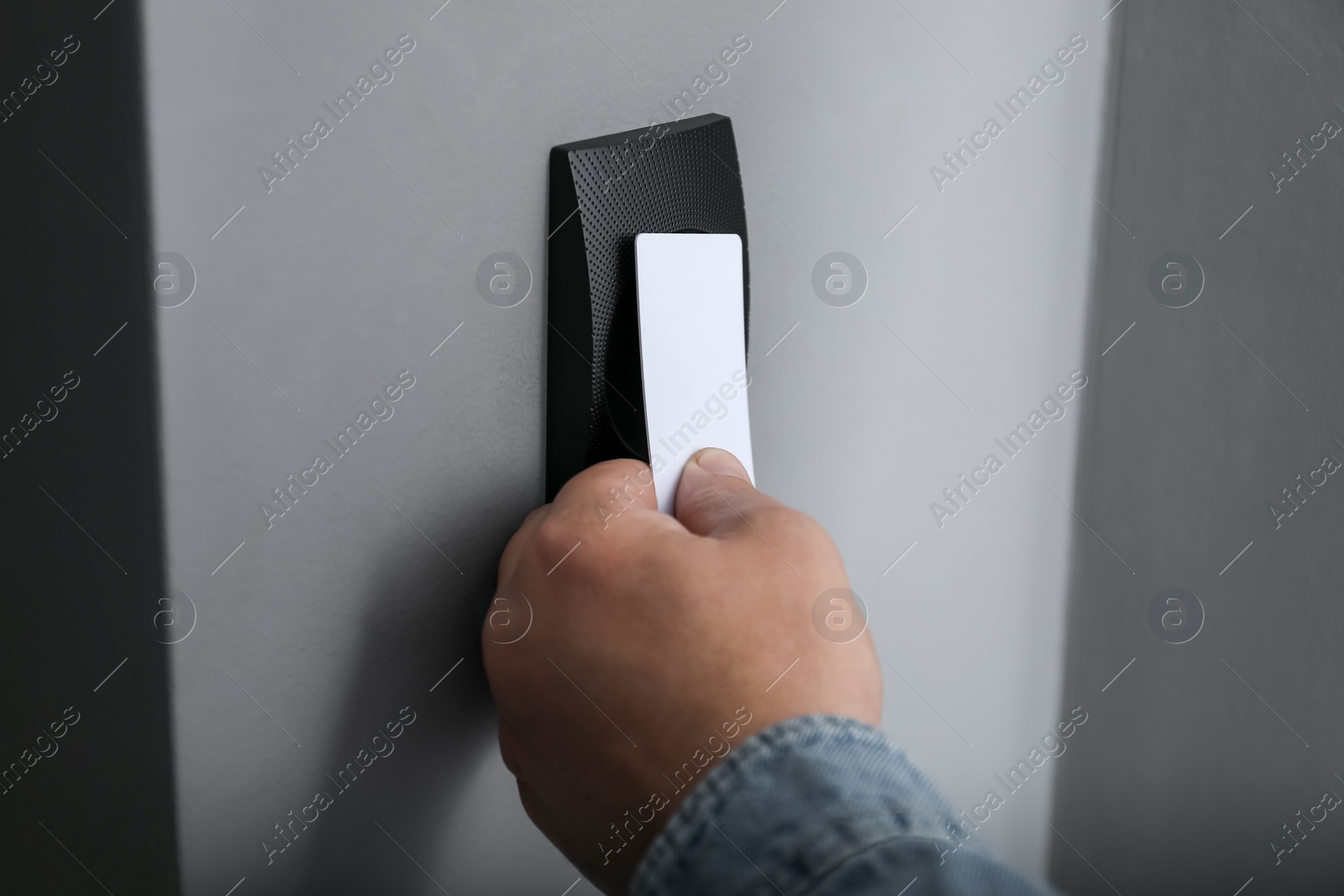 Photo of Man opening magnetic door lock with key card, closeup. Home security