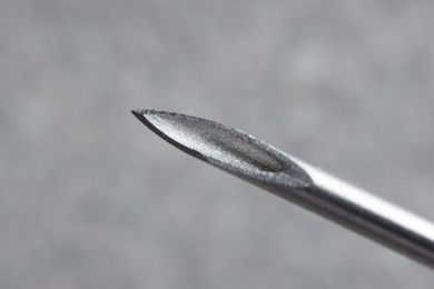 Photo of Macro photo of medical needle on blurred grey background