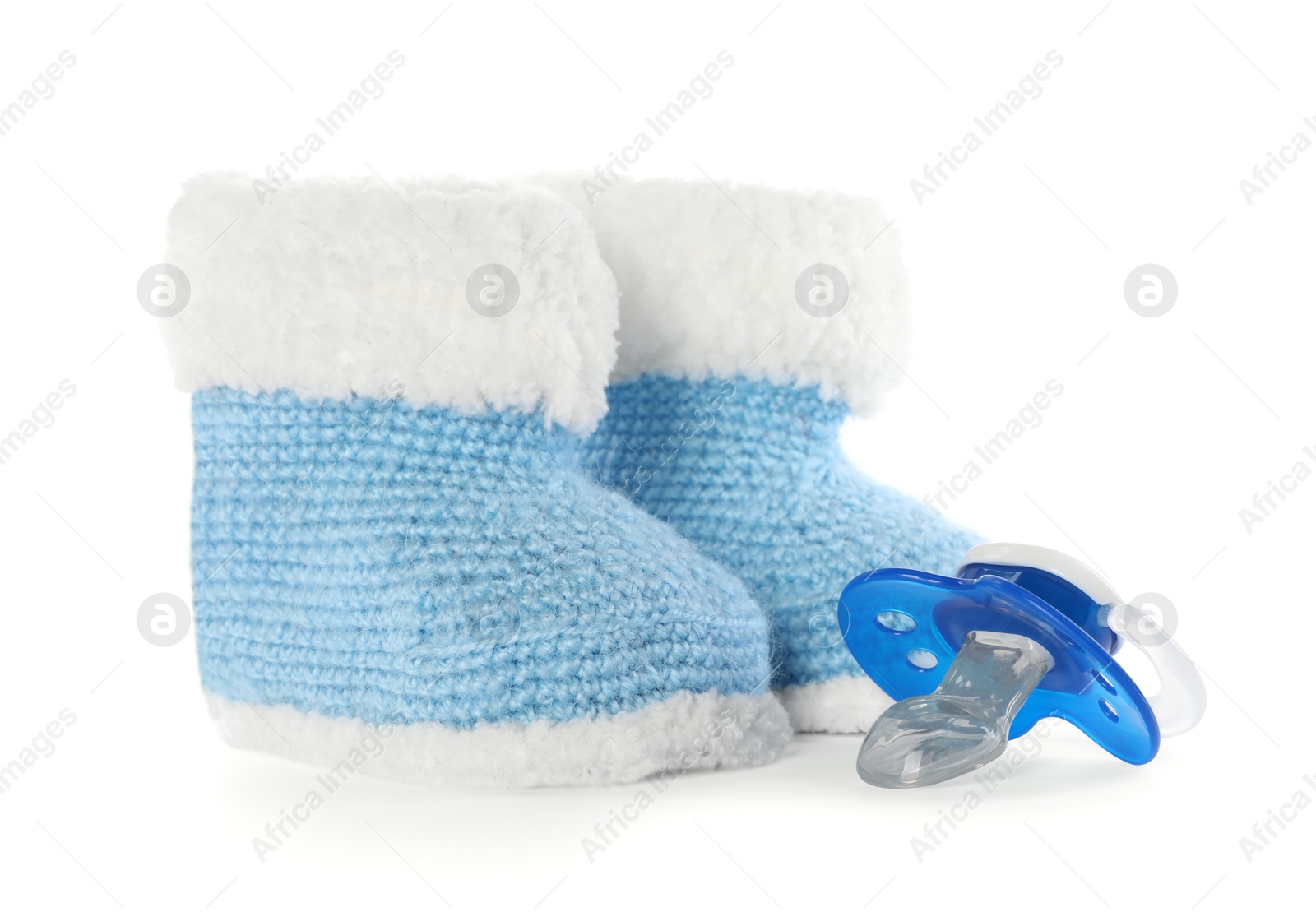 Photo of One baby pacifier and booties isolated on white