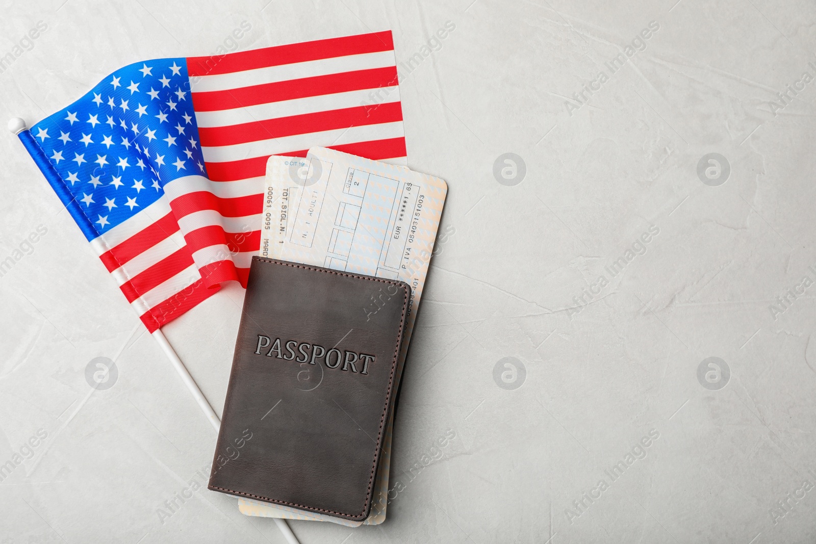Photo of Flat lay composition with flag of USA, passport and tickets on gray background. Space for text
