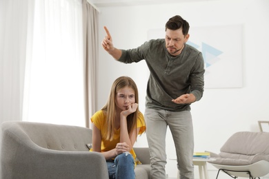 Photo of Father scolding his teenager daughter at home