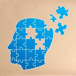 Dementia concept. Drawing of blue head shaped jigsaw puzzle with missing pieces on beige background