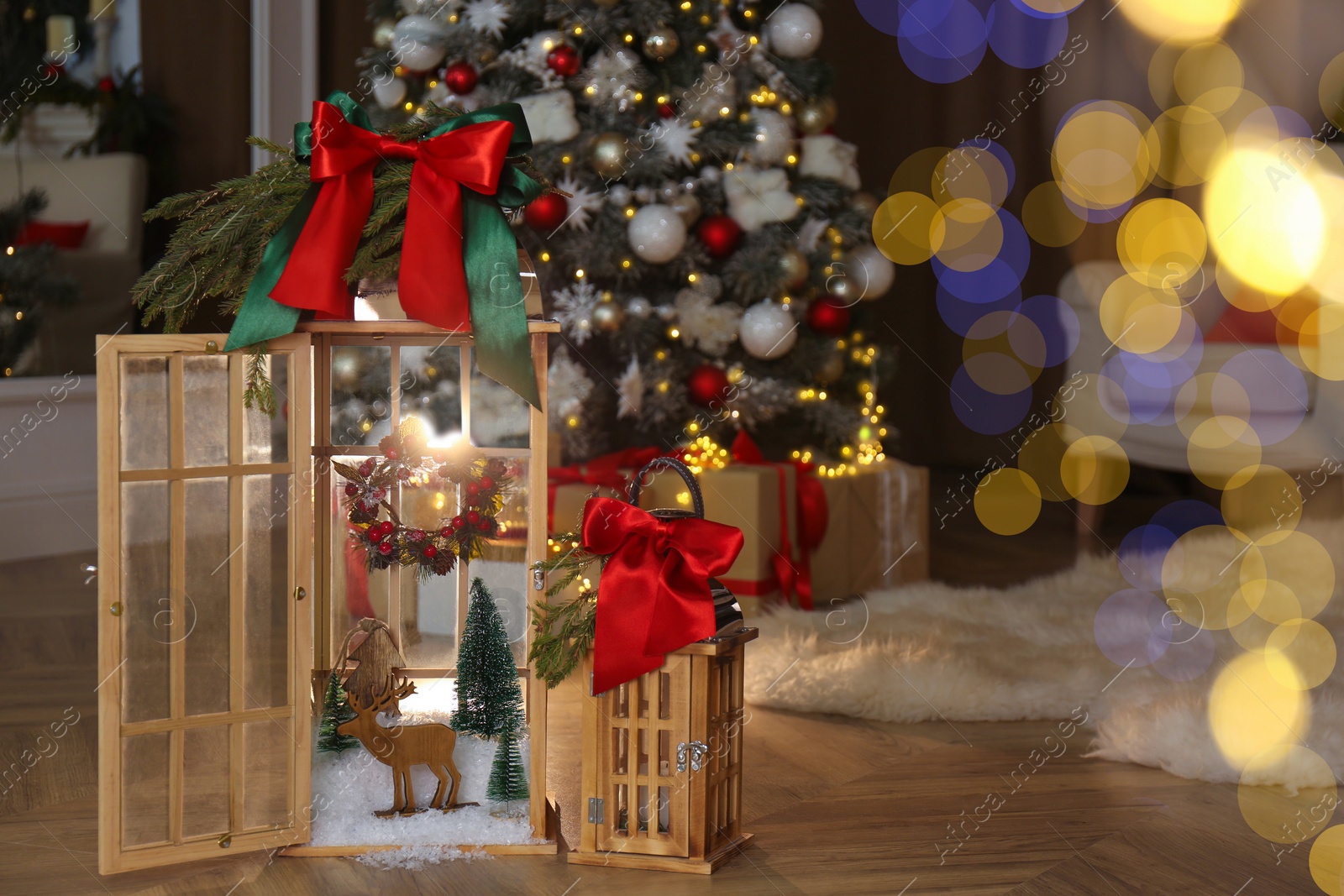 Photo of Beautiful festive lanterns near Christmas tree indoors