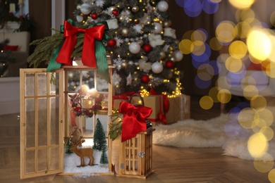 Beautiful festive lanterns near Christmas tree indoors