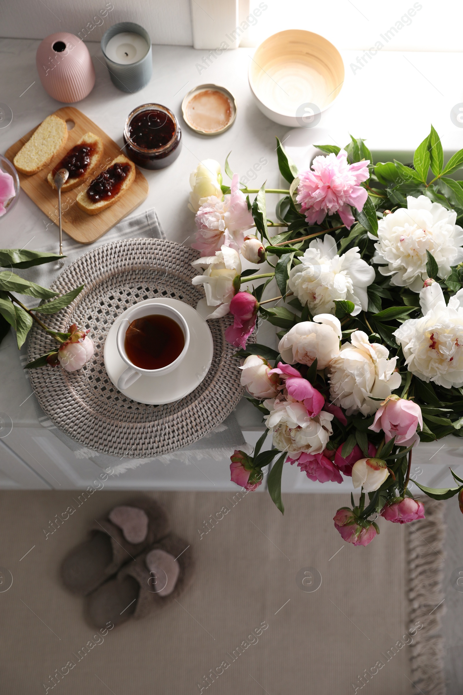 Photo of Beautiful peonies and breakfast on kitchen counter, above view