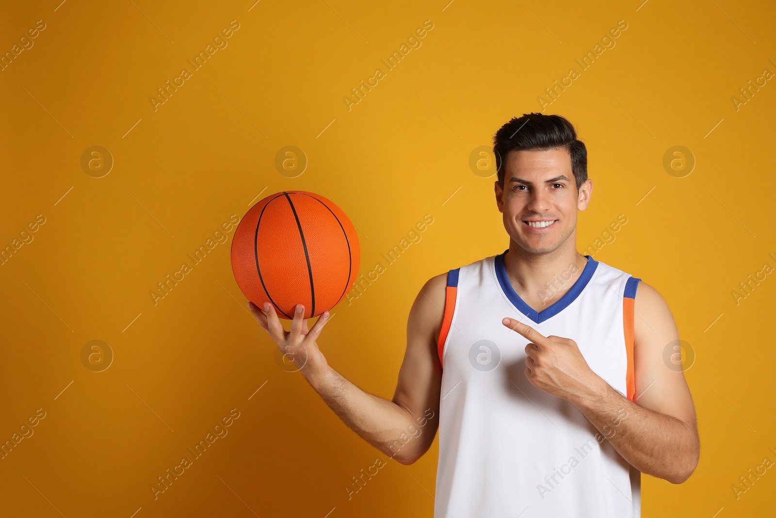 Photo of Basketball player with ball on yellow background