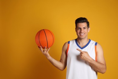 Basketball player with ball on yellow background