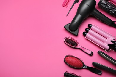 Flat lay composition of professional hairdresser tools on pink background, space for text