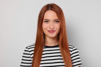 Portrait of beautiful young woman on light gray background