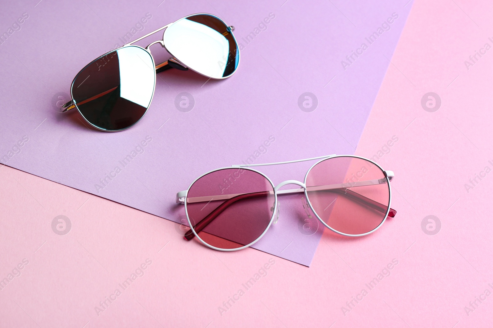 Photo of Stylish sunglasses on color background. Summer time