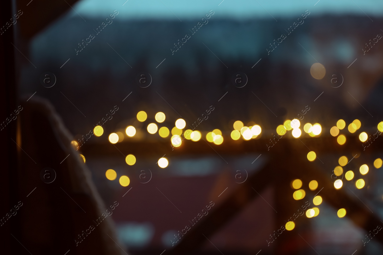 Photo of Blurred view of fence decorated with Christmas lights