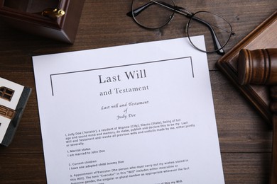 Photo of Last will and testament near glasses, gavel on wooden table, flat lay
