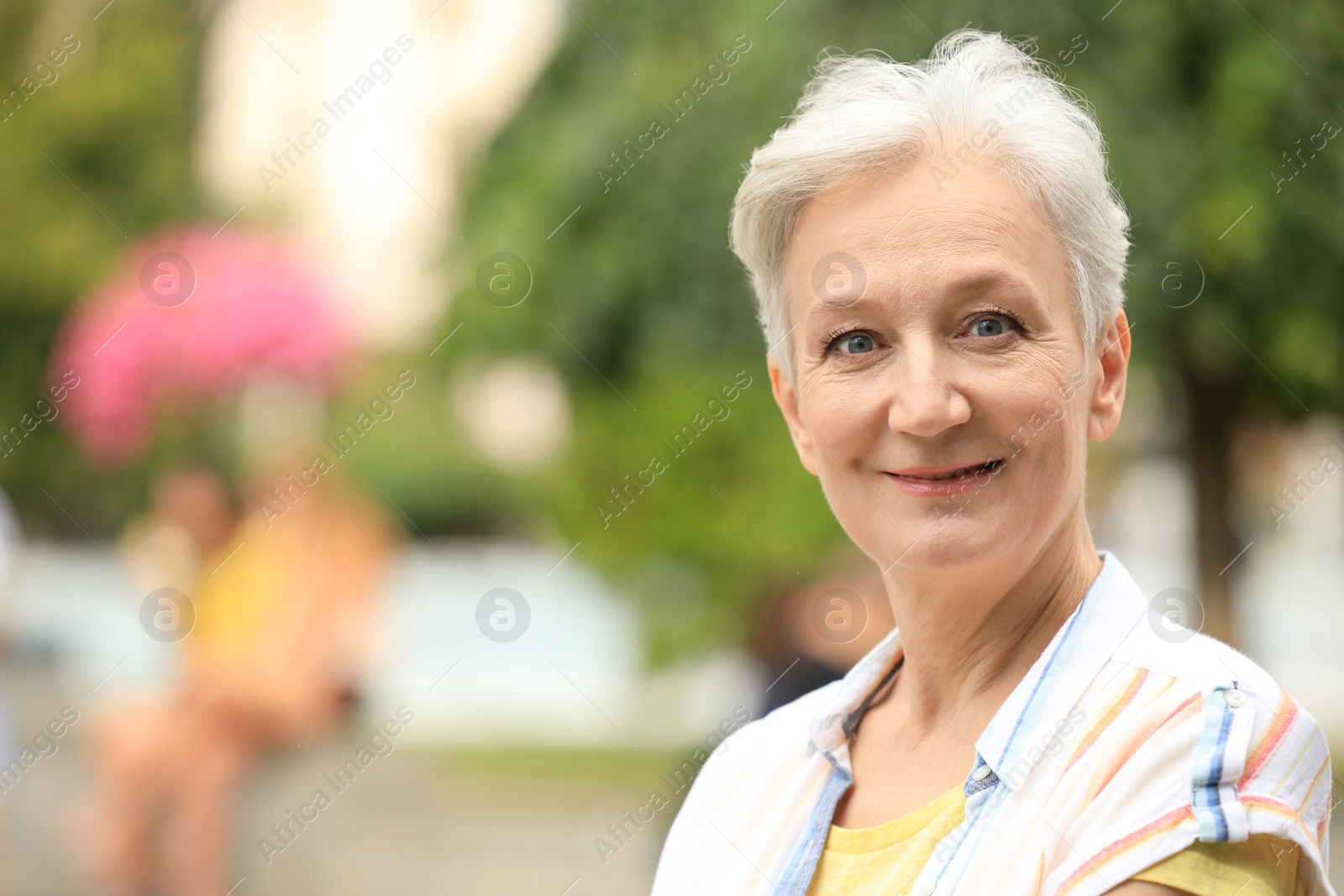 Photo of Portrait of happy mature woman outdoors, space for text. Smart aging