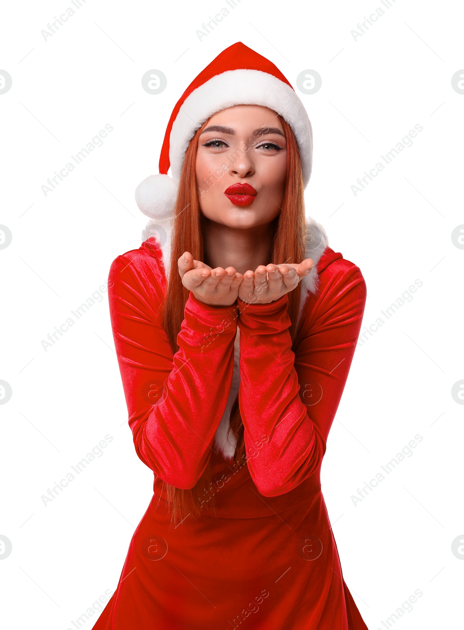 Photo of Young woman in red dress and Santa hat blowing kiss on white background. Christmas celebration