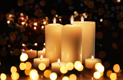 Burning candles on dark background, bokeh effect