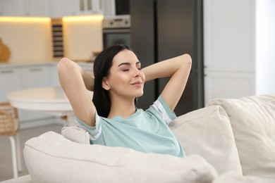 Photo of Young woman relaxing on sofa at home