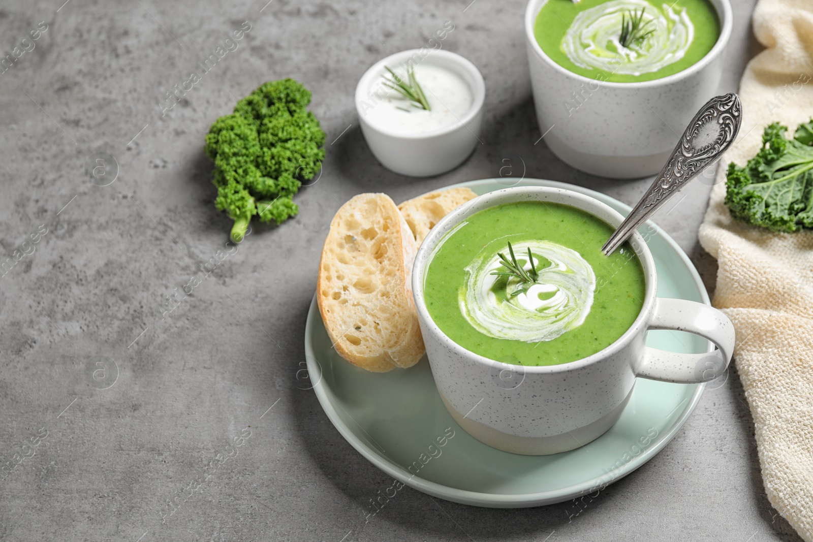 Photo of Tasty kale soup served on grey table