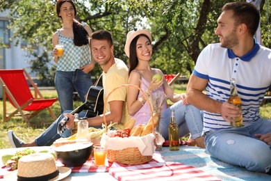 Young people enjoying picnic in park on summer day