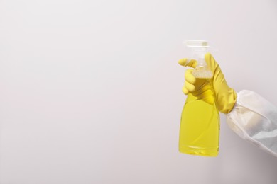 Photo of Woman in protective suit cleaning mold with sprayer on wall, closeup. Space for text
