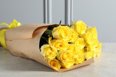 Photo of Beautiful bouquet of yellow roses on light grey table